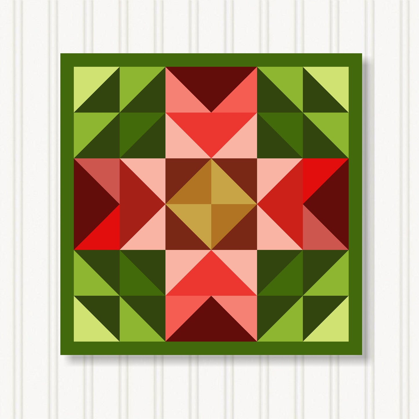 The image is a vibrant and colorful quilt with a geometric pattern of triangles in various shades of green, red, and brown.