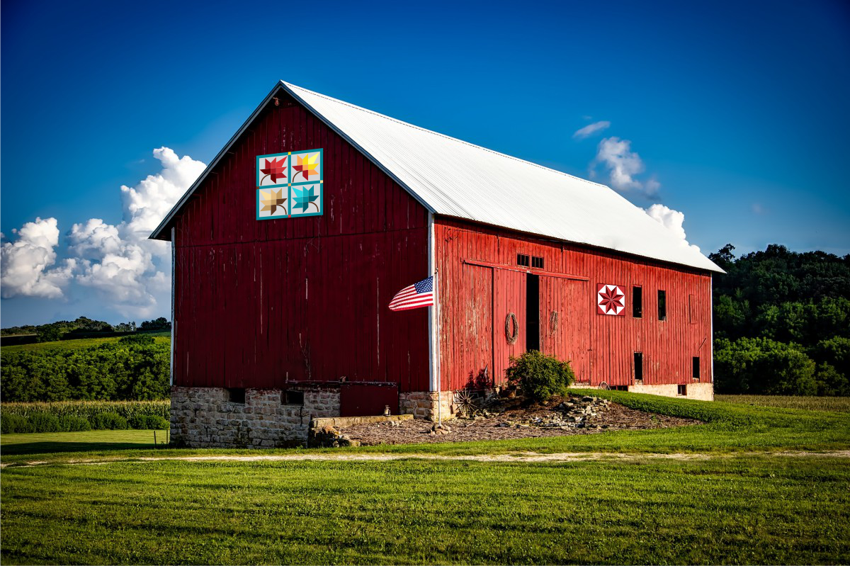 a red barn with a flag on the side of it